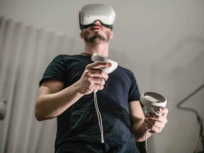 a man wearing a virtual reality headset holding a wii controller